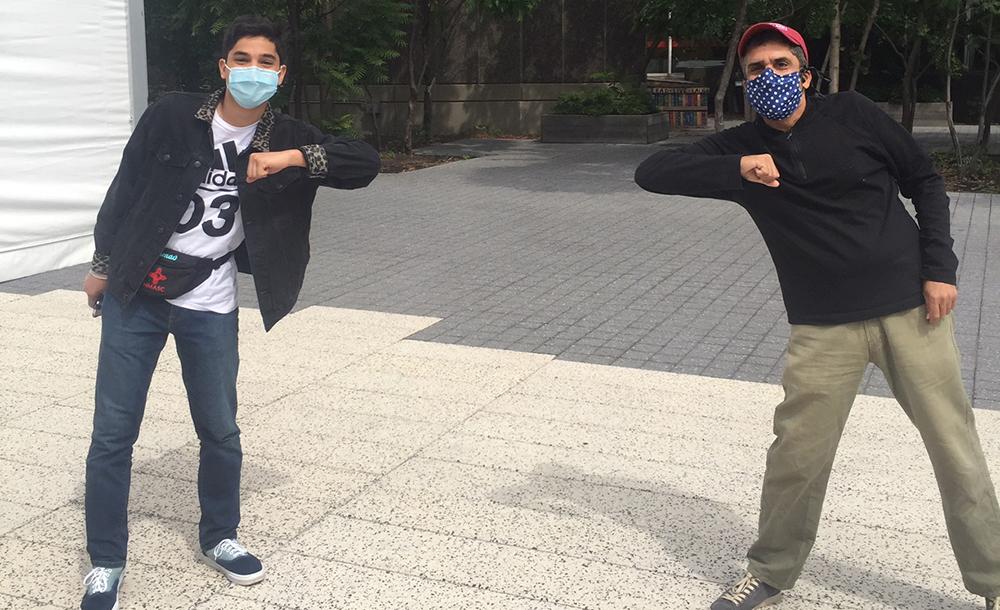 Dean Khurana and student standing far apart with masks