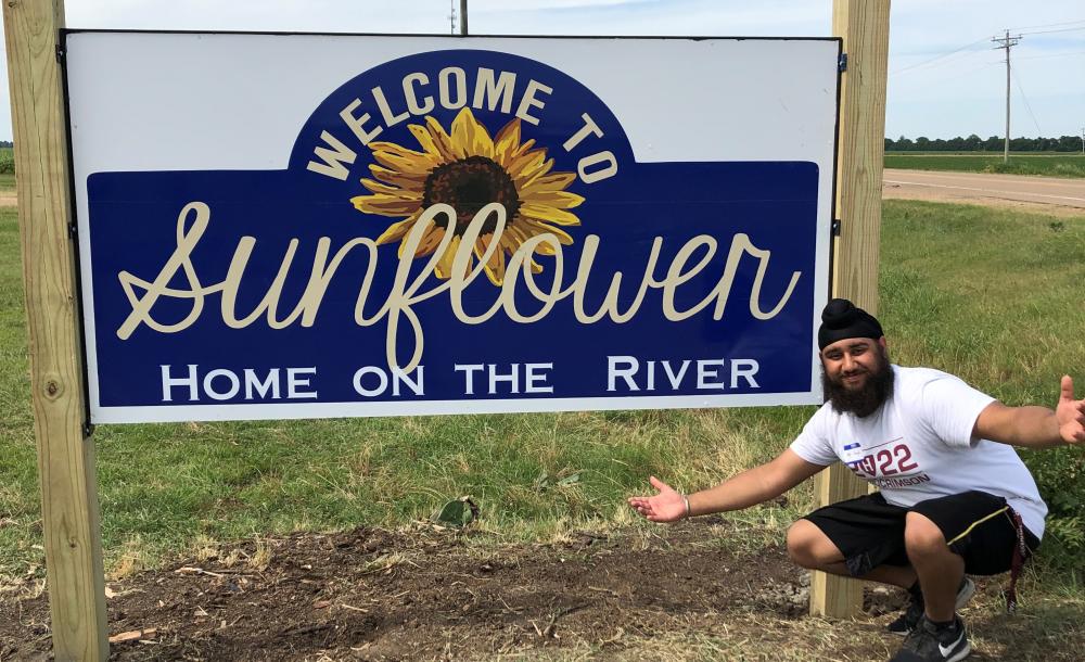 Picture of Harpreet next to the Sunflower County Sign