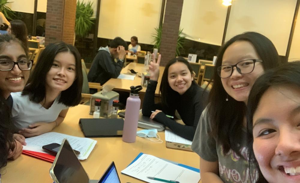 Five girls studying in a college dining hall.