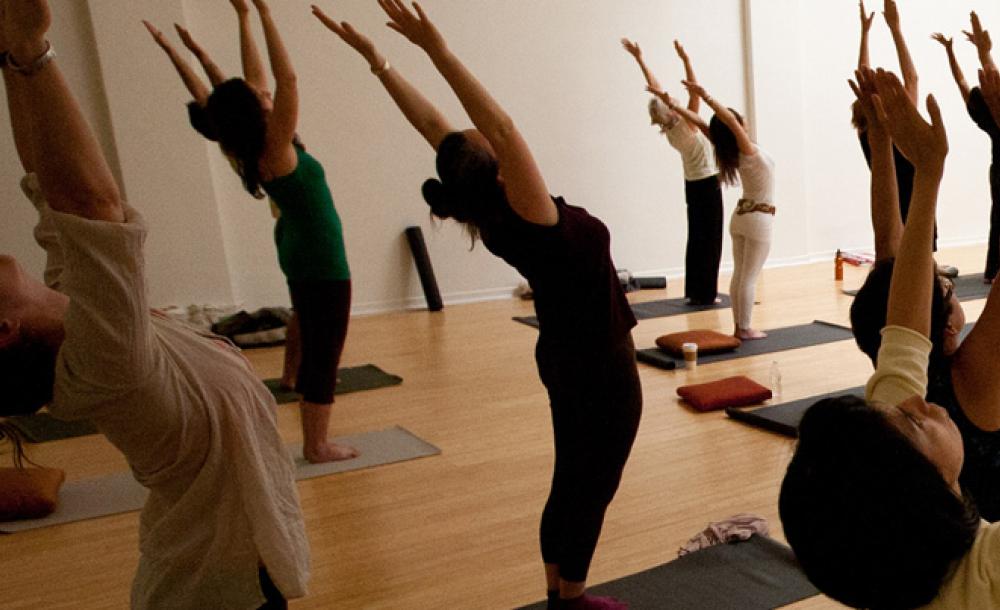 people standing in rows stretching with hand in the air