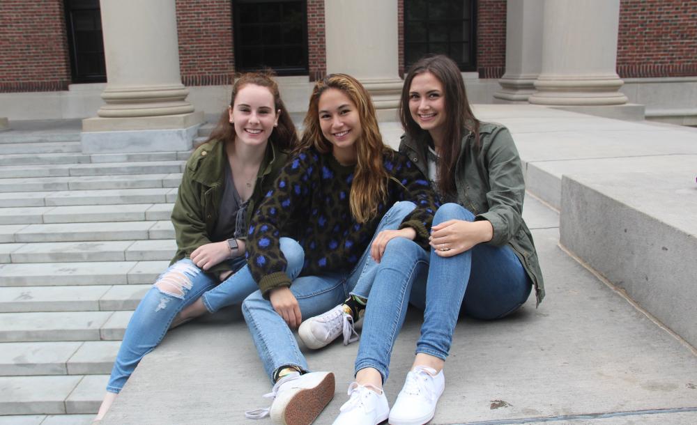 Three friends sitting in front of Widener Library