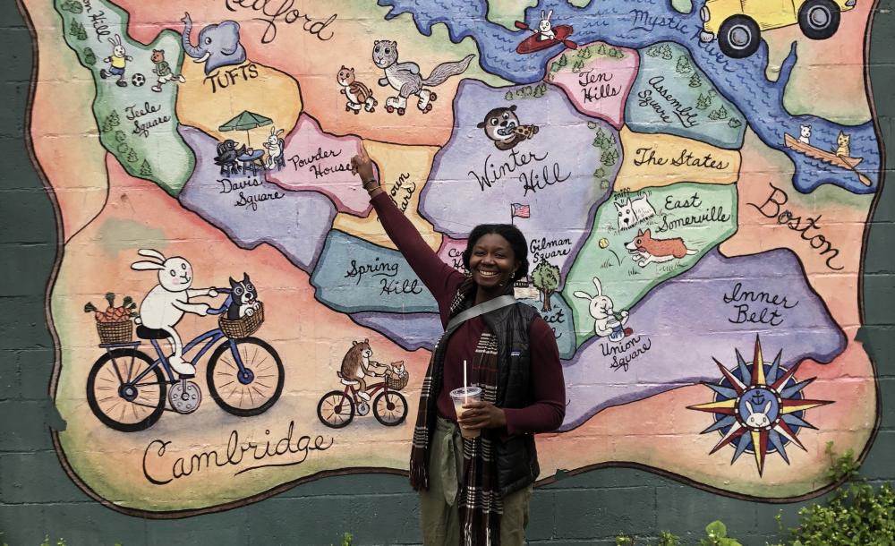 Martha Kebeh stands in front of a colorful map. 