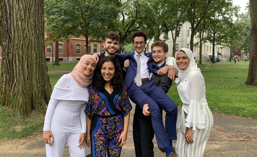 Six friends posing for a photo in Harvard Yard