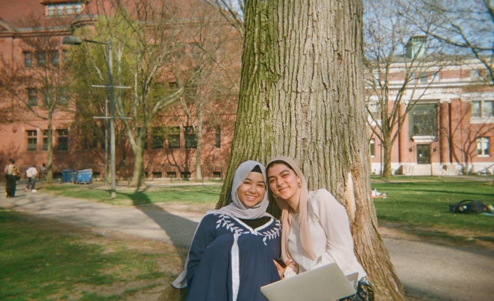 Samia Afrose and Maryam Tourk (co '25) enjoying the weather in Harvard Yard