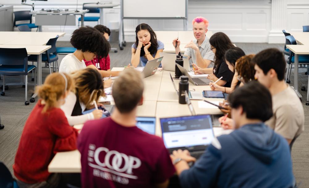 Several students sitting around a table in a classroom.