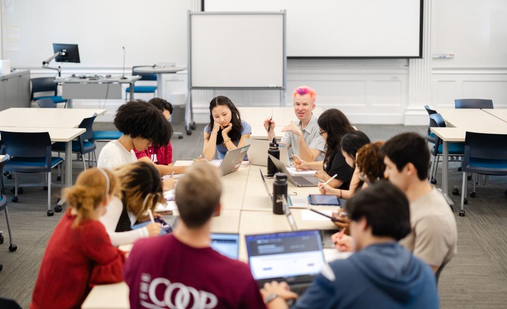 Students sit around a classroom with a professor