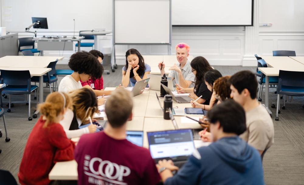 Students sit around a classroom with a professor