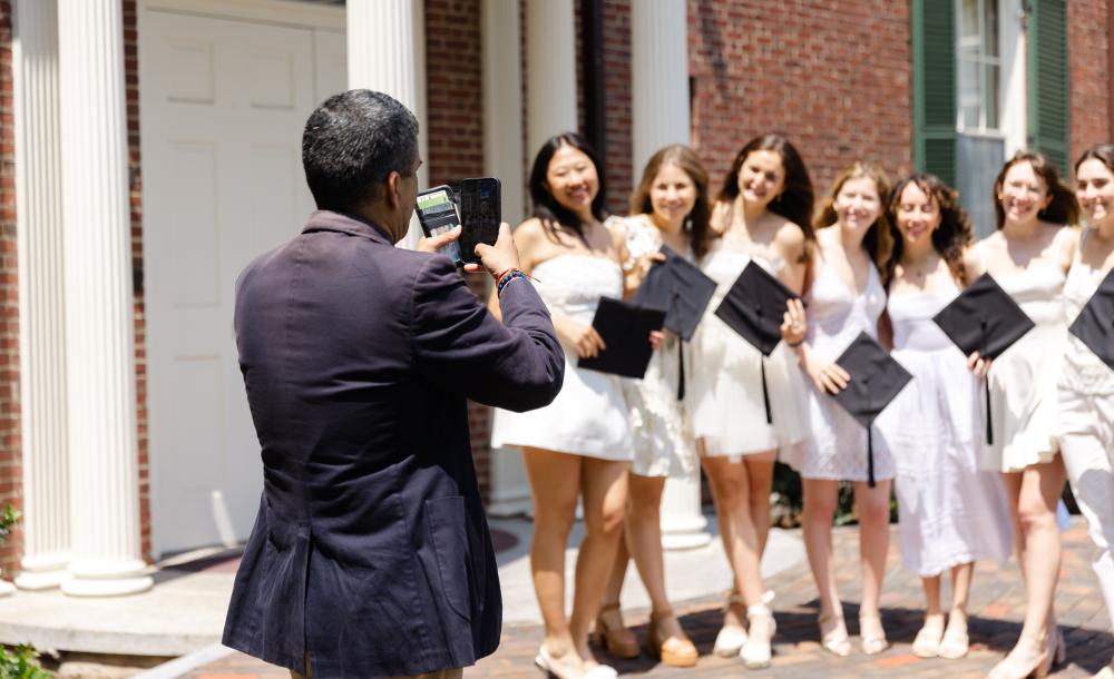 Class of 2023 seniors take a selfie with Dean Khurana in front of Loeb House.