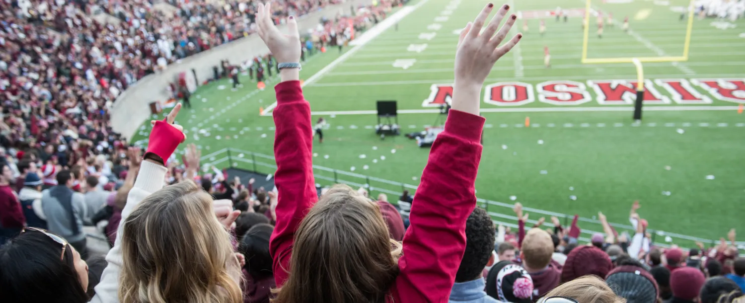 Students cheering at a Harvard football game