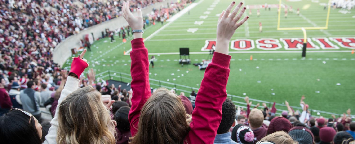 Students cheering at a Harvard football game
