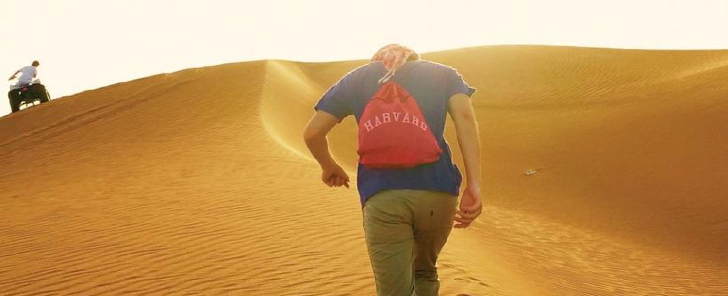 Student with Harvard backpack in desert