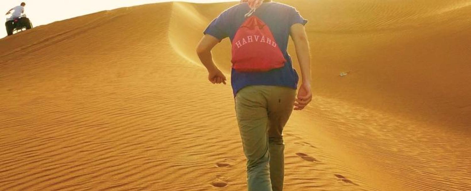 Student with Harvard backpack in desert