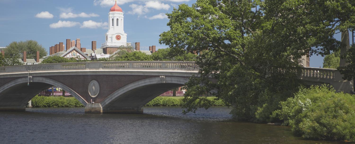 View of a bridge over the Charles river. Harvard campus can be seen in the background.