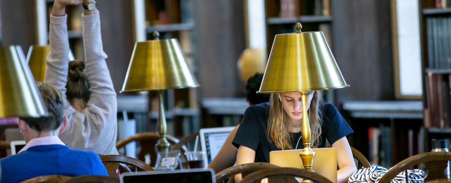 students sitting at a table studying in the library