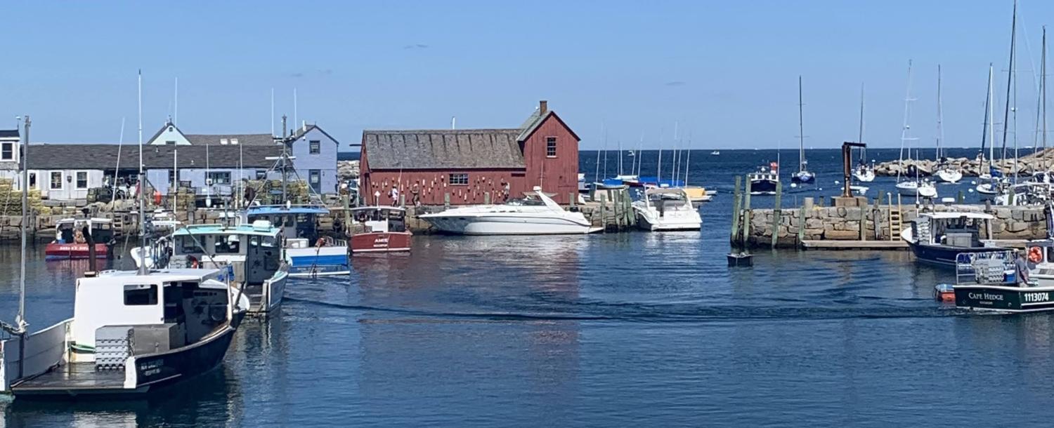 A red farmhouse surrounded by water and boats.