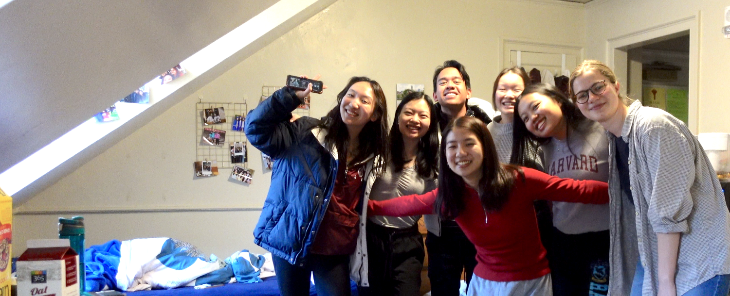 Blocking group of 7 first-years smiling in dorm