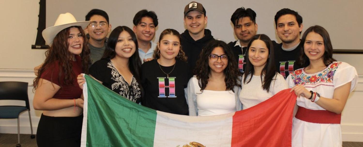 An image of the 11 board members for RAZA of the 2023 year.  They are holding up a Mexican flag. 