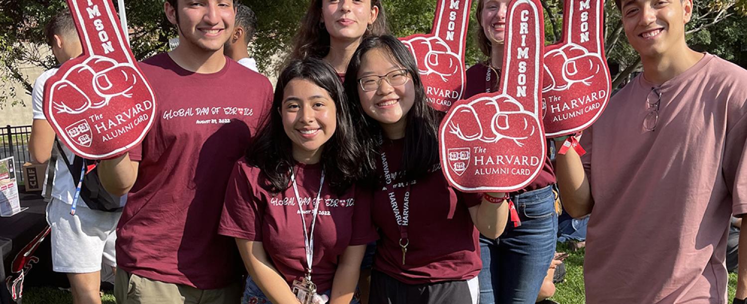 a group of students wearing crimson fan foam finger