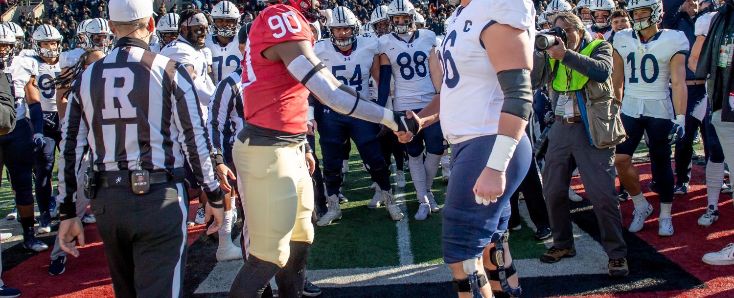 Two football players of the opposing Yale and Harvard teams shake hands