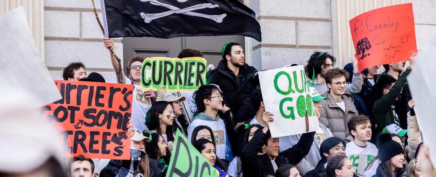 Students from Currier House holding up posters for Housing Day