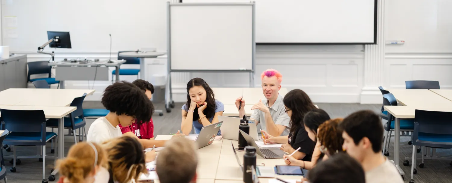 Students sit around a classroom with a professor
