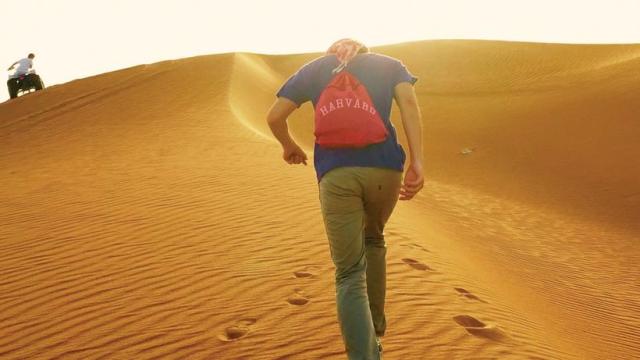 Student with Harvard backpack in desert