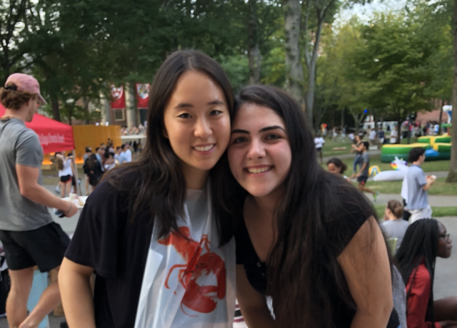 two students eating lobster in Harvard Yard