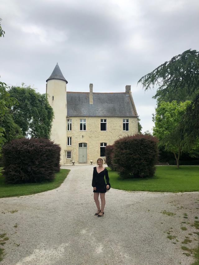 Malia at Chateau Monfreville, a castle in northern France, with greenery and sky in background