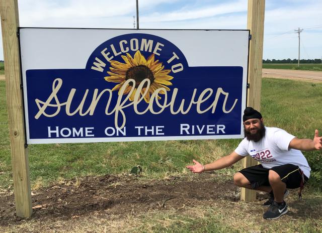 Picture of Harpreet next to the Sunflower County Sign