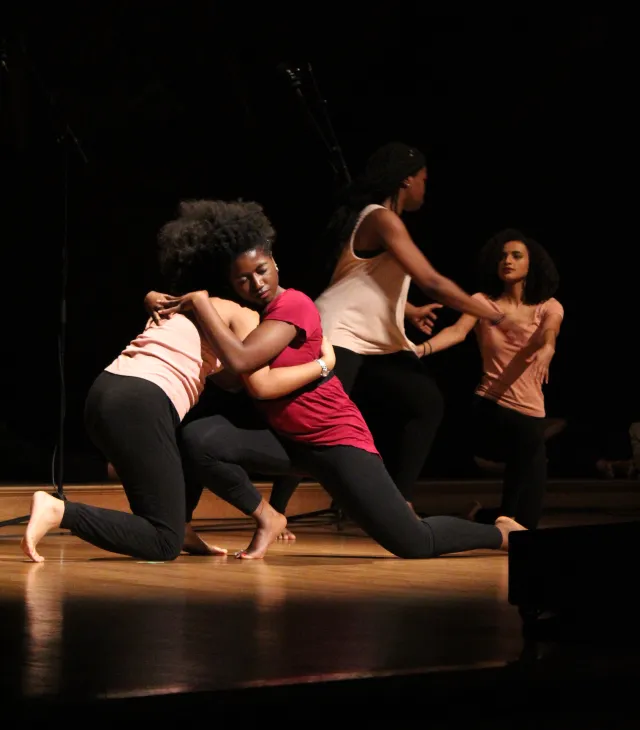 This image shows 4 dancers embracing each other at last year's Kuumba Winter Concert.