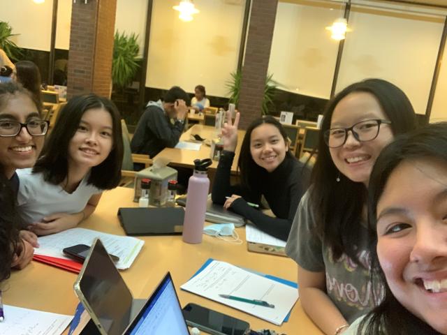 Five girls studying in a college dining hall.