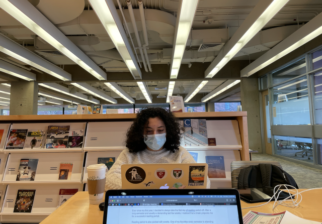 Student typing on computer in a common study space