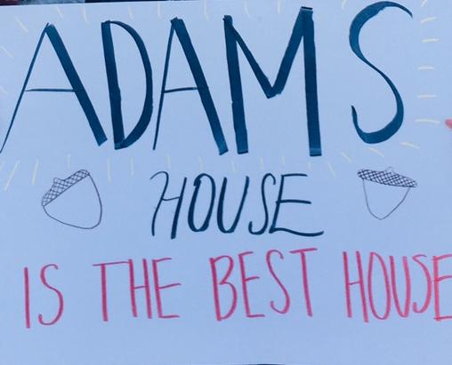 A picture of a white poster with "Adams House is the Best House" written on it.