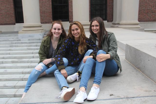 Three friends sitting in front of Widener Library