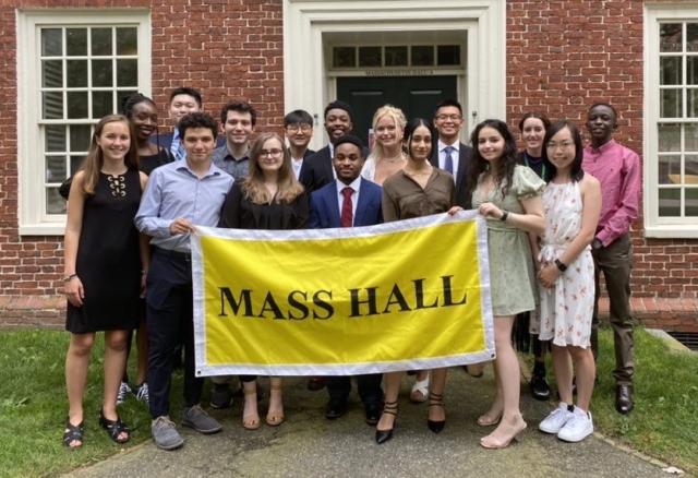 A picture of Mass Hall residents holding a yellow "Mass Hall" banner.