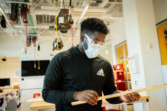 A person looking at a piece of wood