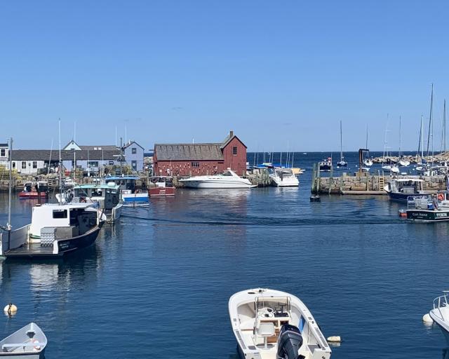 A red farmhouse surrounded by water and boats.