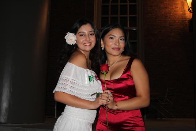 Latinx convocation a celebration for first years. Two girls holding a red rose.