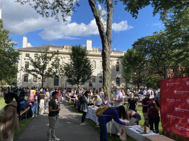 Large number of students walking around a fair that is dedicated to exploring clubs at Harvard