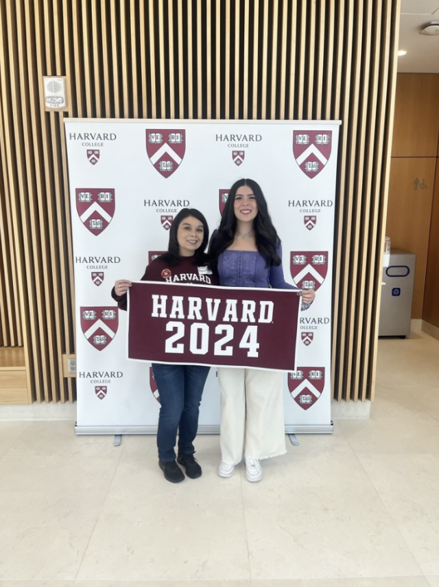 Mom and Daughter smiling with Harvard 2024 sign