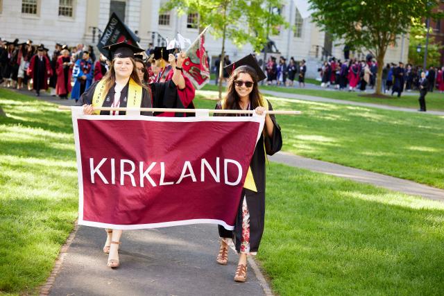 Hannah and a friend carry the Kirkland House banner at Commencement.