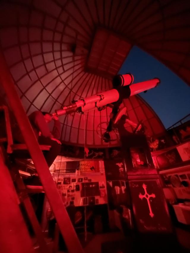 Rafid looking out through the Loomis-Michael student observatory telescope