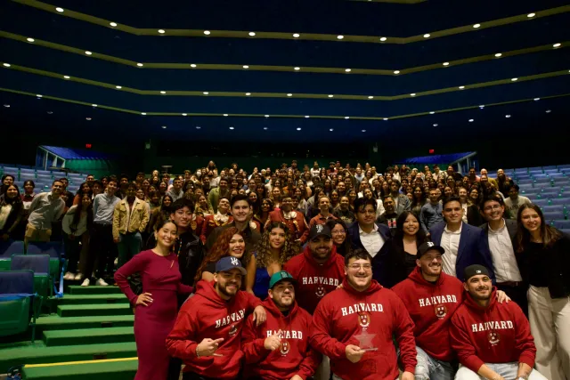 Grupo Frontera band members with the event's guests. People are smiling and happily posing for the picture.  