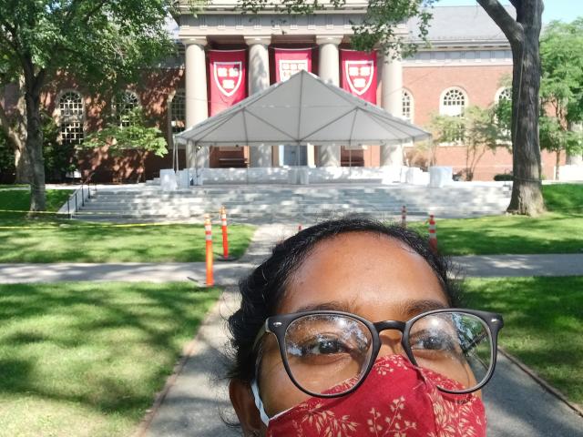 Merlin standing in front of Memorial Church with Veritas banners in the background