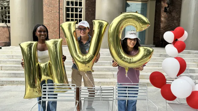 Harvard Votes Challenge student leaders holding HVC balloons on the Memorial Church steps.