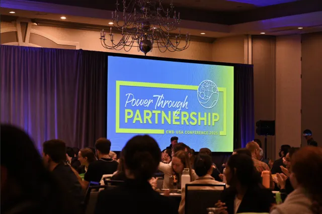Slide with a blue background and green letters spelling "Power Through Partnerships."