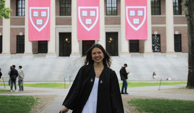 Ana posing in front of the Widener library in her graduation regalia. 