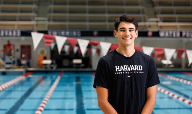 Harvard College Senior Nicola Hensch smiles next to a pool at Harvard's athletic facility.