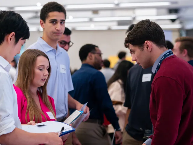  A group of young professionals having a conversation at a busy networking event