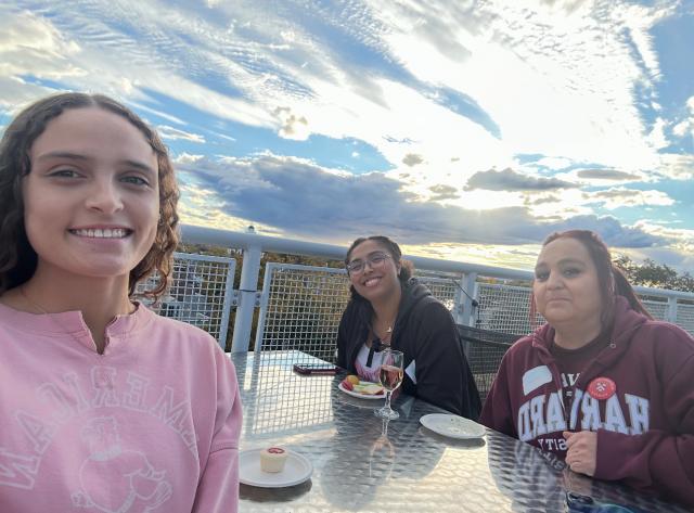 Secquoia, mom and older sister sitting on terrace outside 